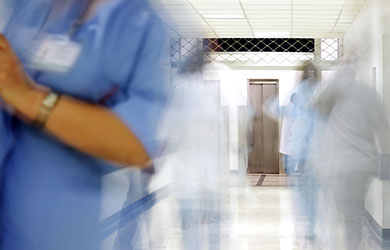 Healthcare professionals, blurred, in a hospital corridor