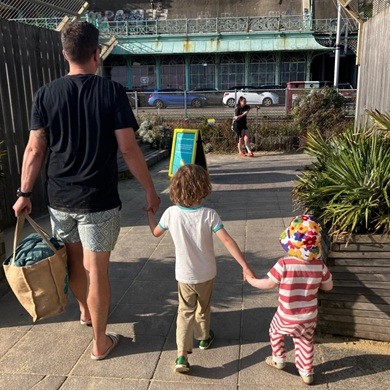 Andy walking with his two young sons, hand in hand.